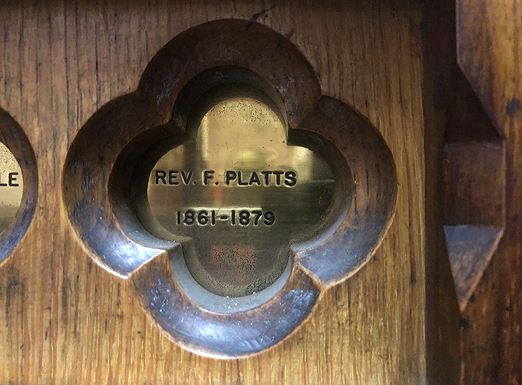 Small brass plaque inset into the wood of the church pulpit.